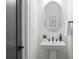 Modern powder room with a sleek pedestal sink and black fixtures at 3937 Plainview Rd, Charlotte, NC 28208