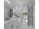 Bright bathroom with double vanity, glass shower, and a view to the main bedroom at 3945 Plainview Rd, Charlotte, NC 28208