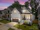 Charming two-story home with white siding and black trim, bathed in the glow of twilight at 3945 Plainview Rd, Charlotte, NC 28208