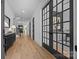 Elegant foyer with hardwood floors, black pane doors, and stylish decor creating a grand entrance at 3945 Plainview Rd, Charlotte, NC 28208