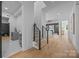 Open hallway leading to the living area with a staircase and a laundry room featuring modern fixtures at 3945 Plainview Rd, Charlotte, NC 28208