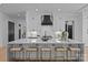 A sleek, contemporary kitchen with a waterfall island, white cabinetry, and bar stool seating at 3945 Plainview Rd, Charlotte, NC 28208