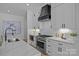A modern kitchen featuring stainless steel appliances, bright white cabinets, and a waterfall kitchen island at 3945 Plainview Rd, Charlotte, NC 28208
