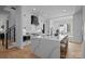 Modern white kitchen featuring a large quartz island, stainless steel appliances, and stylish black accents at 3945 Plainview Rd, Charlotte, NC 28208