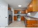 Functional kitchen equipped with stainless steel appliances, wooden cabinets, and tile flooring at 402 Beaver Dam Church Rd, Shelby, NC 28152