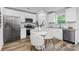 Modern kitchen with stainless steel appliances, white cabinets, granite counters, and an adjacent dining area at 4474 Pebblebrook Sw Cir, Concord, NC 28027