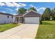 Beautiful single-Gathering home with a large driveway leading to an attached white garage, surrounded by green lawn at 455 Contentment Ct # 18, Kannapolis, NC 28081