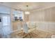Chic dining area with a glass table, white chairs, and view of the kitchen at 5909 Cougar Ln, Charlotte, NC 28269