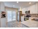 Modern kitchen with stainless steel appliances, white cabinets, and a sliding door to the backyard at 5909 Cougar Ln, Charlotte, NC 28269