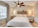 Cozy main bedroom with a tufted headboard, mirrored nightstands, and a ceiling fan for comfort at 5909 Cougar Ln, Charlotte, NC 28269