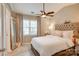 Bright bedroom with a large window, ceiling fan, tufted headboard, and decorative mirror at 5909 Cougar Ln, Charlotte, NC 28269