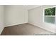 Clean and carpeted bedroom featuring a window overlooking green foliage at 626 Wabash Ave # 6, Charlotte, NC 28208