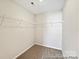Empty walk-in closet with white wire shelving and neutral carpeting, ready for customization at 626 Wabash Ave # 6, Charlotte, NC 28208