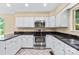 Well-lit kitchen with stainless steel appliances, granite counters, and white cabinetry at 698 Normandy Rd, Mooresville, NC 28117
