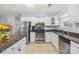 This kitchen features bright white cabinetry, stainless steel appliances, granite countertops and tile flooring at 698 Normandy Rd, Mooresville, NC 28117