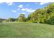 Expansive green backyard with a shed surrounded by lush trees and a blue sky at 746 Joe Lentz Rd, Salisbury, NC 28146