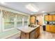 Bright kitchen featuring an island with sink, wooden cabinets, and hardwood flooring at 746 Joe Lentz Rd, Salisbury, NC 28146