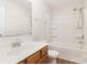 A well-lit bathroom is equipped with a bath-shower combo and wooden cabinets at 7643 Monarch Birch Ln, Charlotte, NC 28215