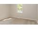 This cozy bedroom features neutral carpet, paint, and a window providing ample natural light at 835 Carrington Dr, Charlotte, NC 28214
