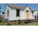 Exterior view of a white home featuring a bright yellow front door and vinyl siding at 1004 S Ridge Ave, Kannapolis, NC 28083