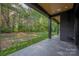 Covered back porch overlooking a spacious lawn and lush trees, perfect for outdoor relaxation and entertainment at 10119 Laurier Ln, Huntersville, NC 28078