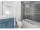 Bright bathroom featuring a sleek vanity, toilet, and glass enclosed shower-tub combo with tiled walls at 10119 Laurier Ln, Huntersville, NC 28078