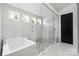 Luxurious bathroom featuring a soaking tub, glass shower, and marble tile at 10119 Laurier Ln, Huntersville, NC 28078