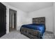 Cozy bedroom with a rustic wooden bed frame and stylish bedding for a warm and inviting atmosphere at 10119 Laurier Ln, Huntersville, NC 28078