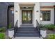 Welcoming front door with dark accents, modern lighting, and professionally landscaped yard at 10119 Laurier Ln, Huntersville, NC 28078