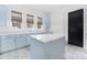 Laundry room featuring custom blue cabinets, island and patterned tile floors at 10119 Laurier Ln, Huntersville, NC 28078