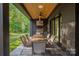 Stylish outdoor kitchen with a grill, dining table, and seating at 10119 Laurier Ln, Huntersville, NC 28078
