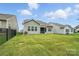 Manicured backyard featuring a lush green lawn and view of house with screened in porch at 10120 Berkeley Castle Dr, Charlotte, NC 28273