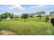 Expansive backyard featuring a lush green lawn with a few trees and neighboring houses at 10120 Berkeley Castle Dr, Charlotte, NC 28273