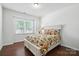 Bright bedroom with a large window, hardwood floors, and a comfortable floral patterned bed at 10120 Berkeley Castle Dr, Charlotte, NC 28273
