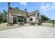 Elegant brick home with spacious patio, perfect for outdoor entertaining with tables and rocking chairs at 10120 Berkeley Castle Dr, Charlotte, NC 28273