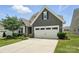 Charming home with a two-car garage and landscaped front yard on a sunny day at 10120 Berkeley Castle Dr, Charlotte, NC 28273