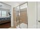 Tiled walk-in shower with glass door and built-in seat next to a bedroom in the home at 10120 Berkeley Castle Dr, Charlotte, NC 28273