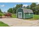 Exterior of the shed with white trim and a red brick patio with green and red landscaping at 1069 Heather Glen Dr, Catawba, NC 28609