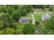 An aerial view of the property displaying the surrounding neighborhood, mature trees and the backyard patio at 115 Fox Run Dr, Fort Mill, SC 29715