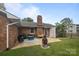 Cozy back patio with outdoor seating, brick chimney, and green lawn at 115 Fox Run Dr, Fort Mill, SC 29715