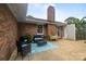 Comfortable back patio with blue rug, brick chimney, and outdoor seating at 115 Fox Run Dr, Fort Mill, SC 29715
