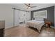 Bright bedroom with hardwood floors, ceiling fan, and sliding barn doors to the bathroom at 115 Fox Run Dr, Fort Mill, SC 29715