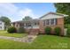Charming brick home featuring a well-manicured lawn and inviting front porch with steps at 115 Fox Run Dr, Fort Mill, SC 29715