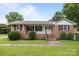 Charming brick home featuring a well-manicured lawn and inviting front porch with double door entry at 115 Fox Run Dr, Fort Mill, SC 29715