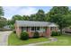 A well-maintained brick home with tidy landscaping, a quaint front porch, and an American flag at 115 Fox Run Dr, Fort Mill, SC 29715