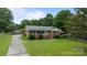 Charming one story brick home with a well-manicured lawn, American flag, and inviting front porch at 115 Fox Run Dr, Fort Mill, SC 29715