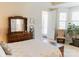 Cozy bedroom featuring a dresser with mirror, chair, and large windows for natural light at 1156 Mckee Farm Ln, Belmont, NC 28012