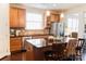 Well-lit kitchen featuring wooden cabinetry, granite counters, an island, and stainless steel appliances at 1156 Mckee Farm Ln, Belmont, NC 28012