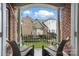 Relaxing balcony view looking towards the backyard, with brick and a pair of relaxing wicker chairs at 11724 Easthampton Cir, Charlotte, NC 28277