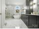 Luxurious bathroom featuring a freestanding tub, glass-enclosed shower, and stylish dark cabinets at 11724 Easthampton Cir, Charlotte, NC 28277